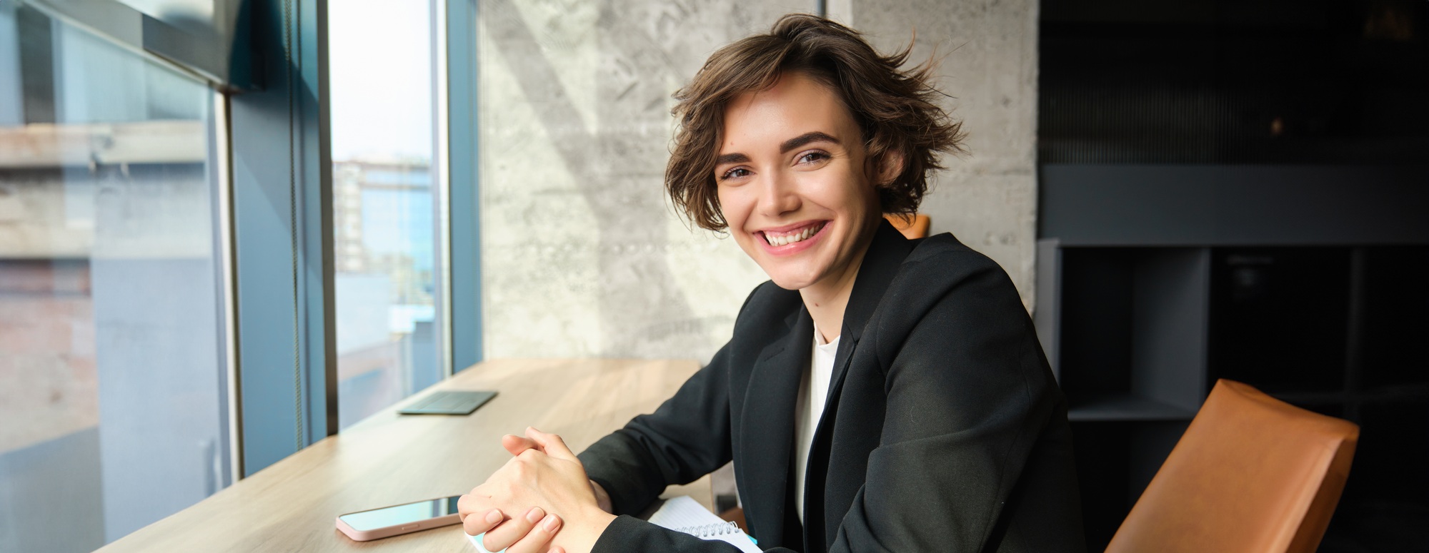 Young woman working in corporate, studying the case in her office, sitting in front of computer in