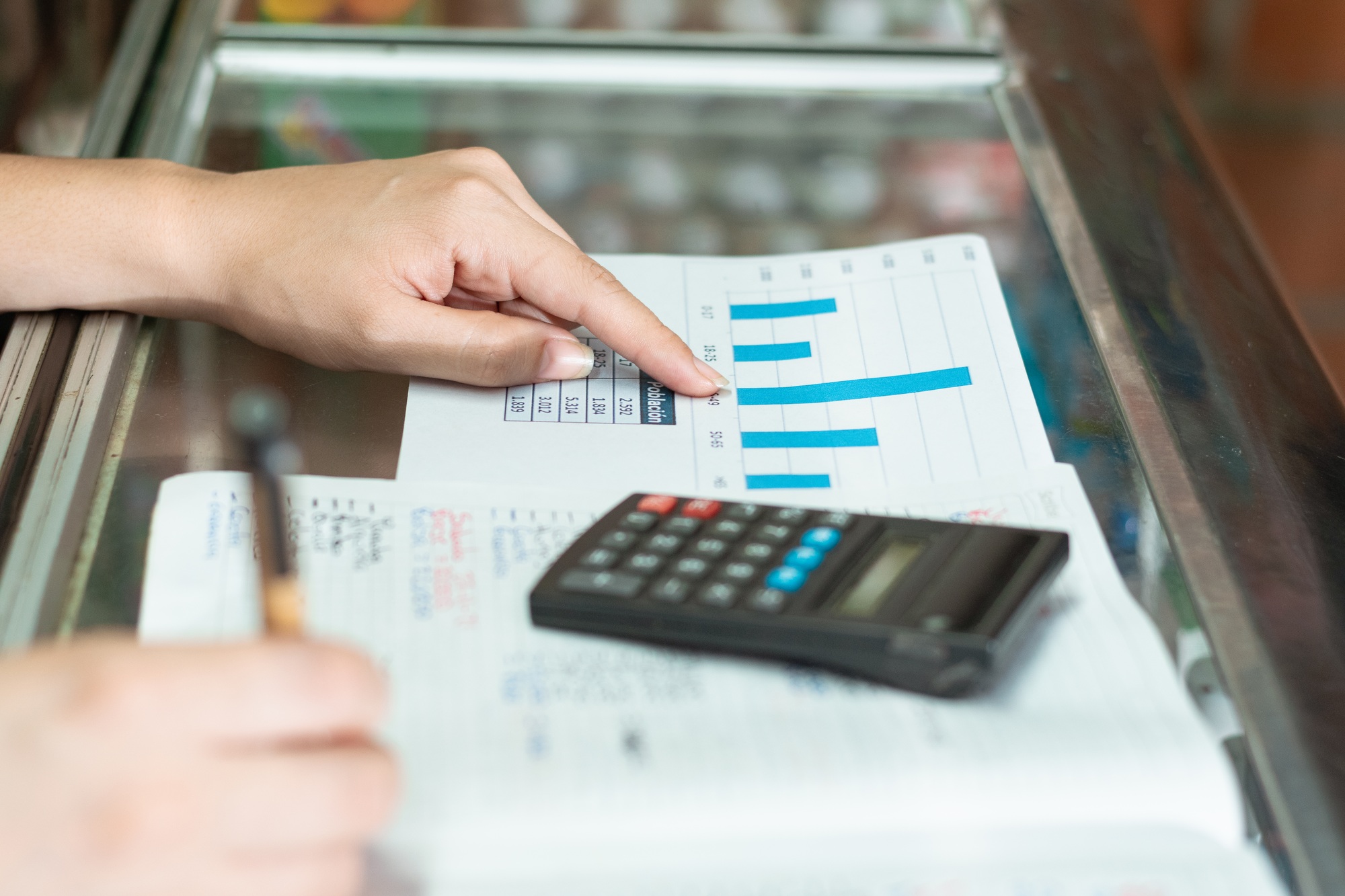 a girl's hand pointing to her business statistics graph. writing with an eco-friendly cardboard pen