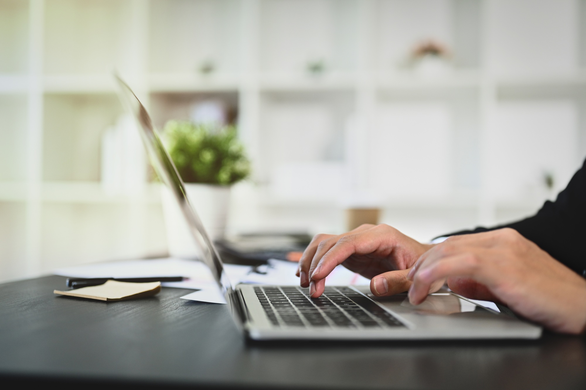Businessman hands typing on keyboard, sending emails to his business partners.