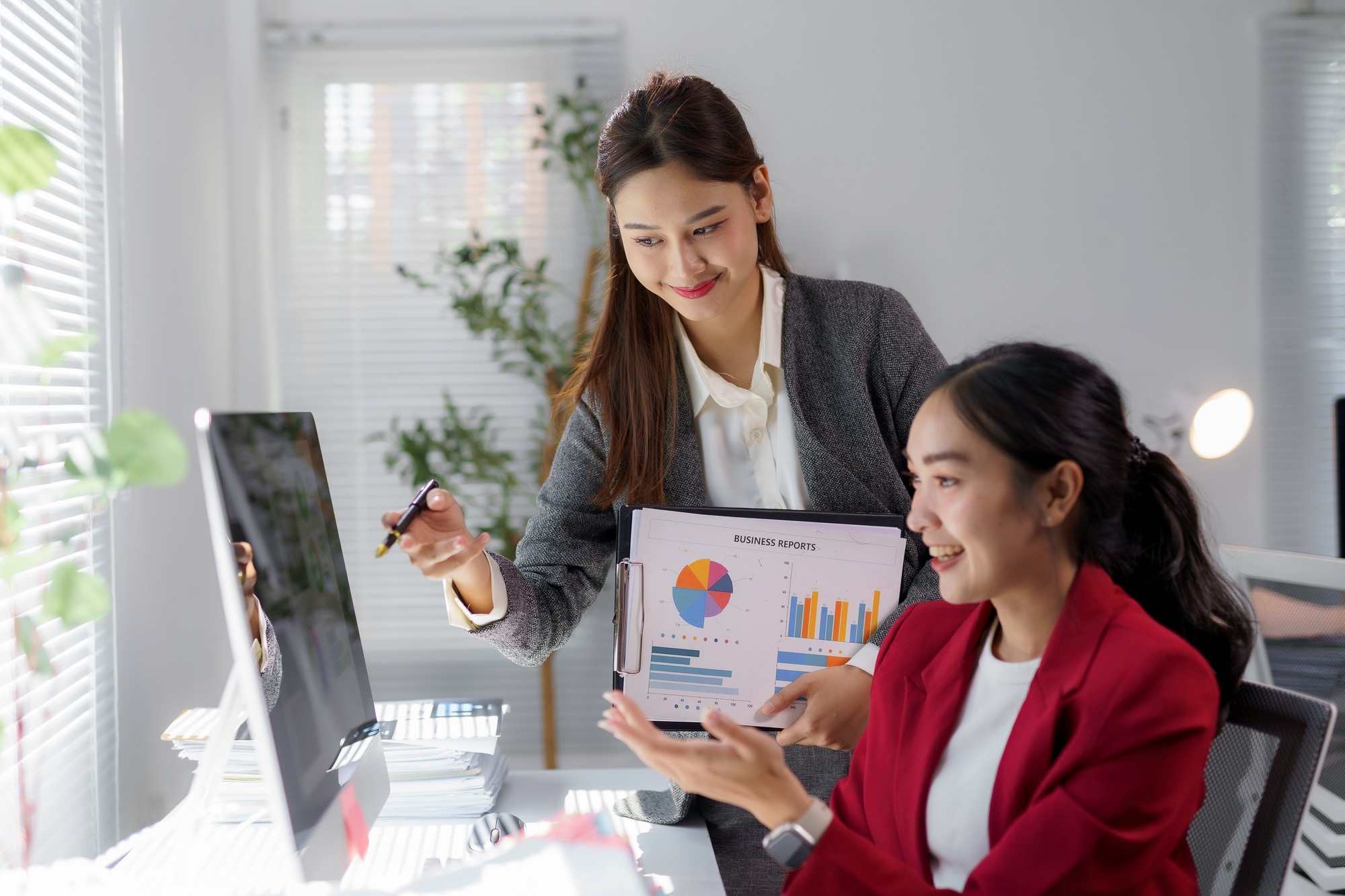 Businesswomen discussing marketing strategy pointing at computer screen