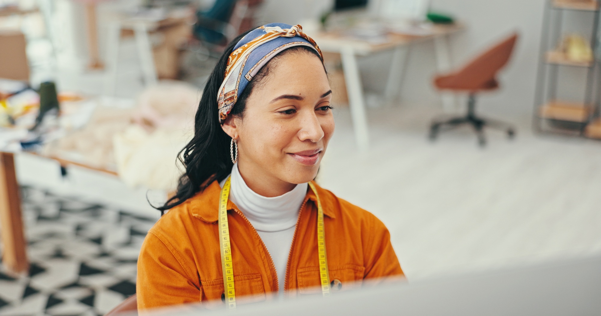 Happy, woman and fashion designer on tablet at office for online orders, delivery and supply chain.