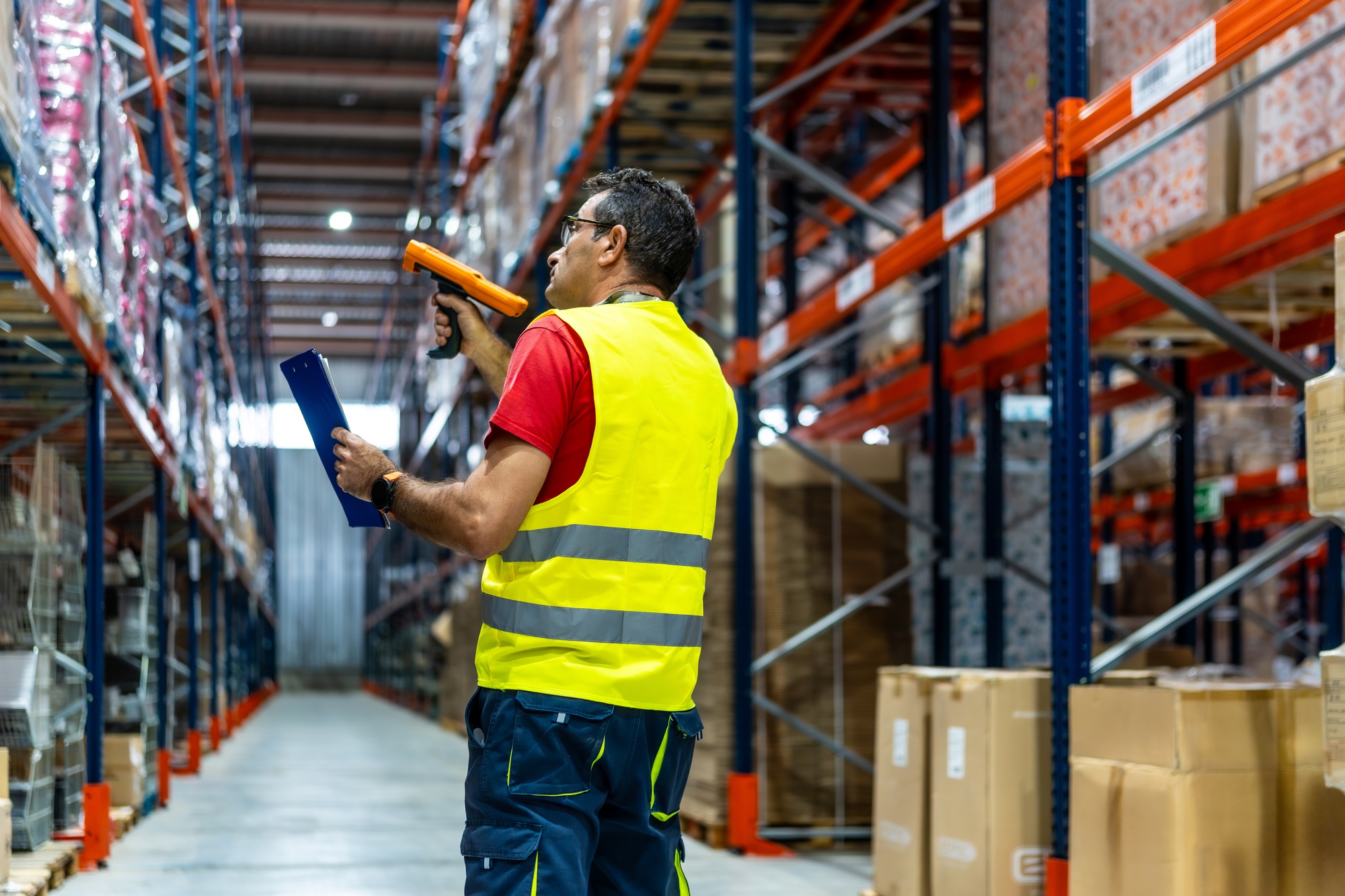 Man taking inventory in a modern storage warehouse