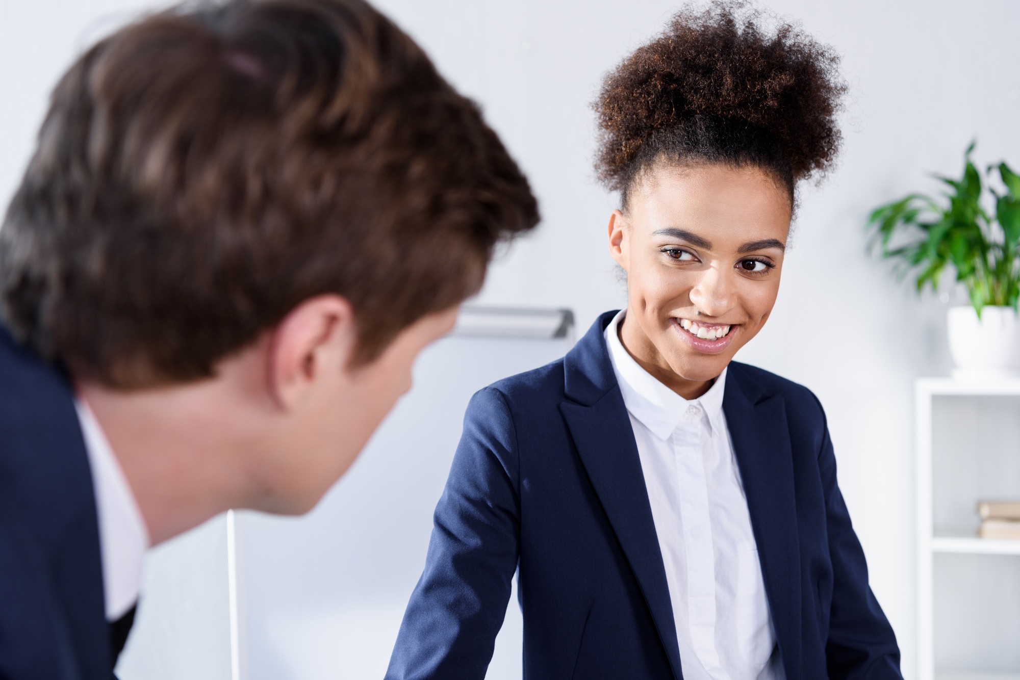 selective focus of smiling african american businesswoman looking at colleague