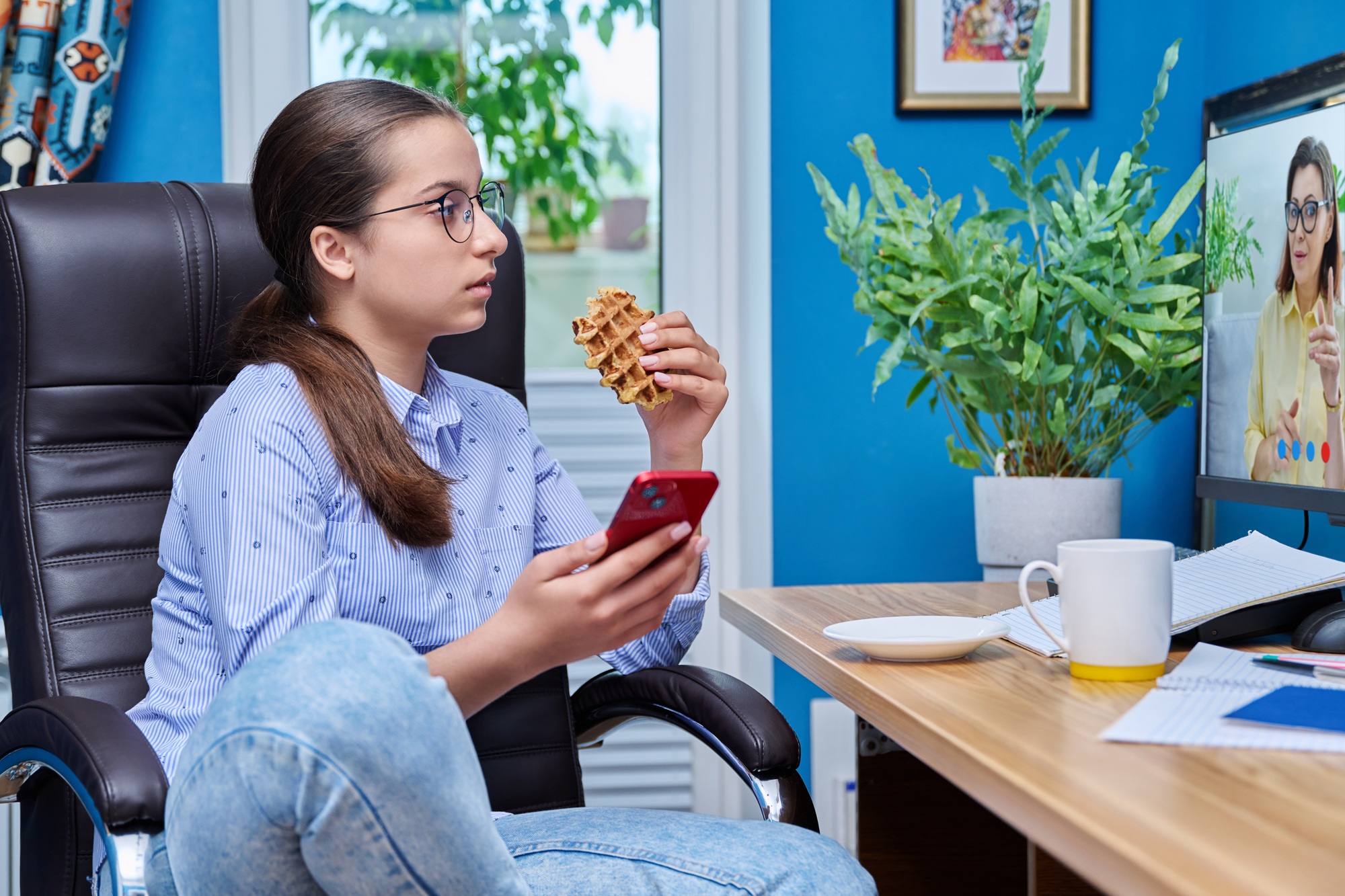 Teenage girl watching training course sitting at table at home