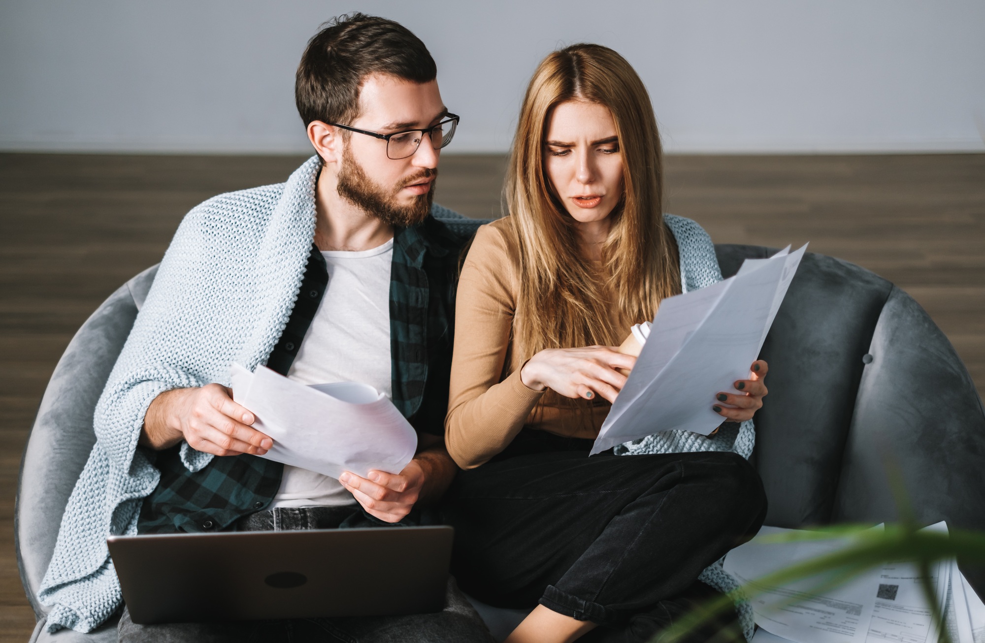 Young couple manages finances with laptop, looking through their bank accounts