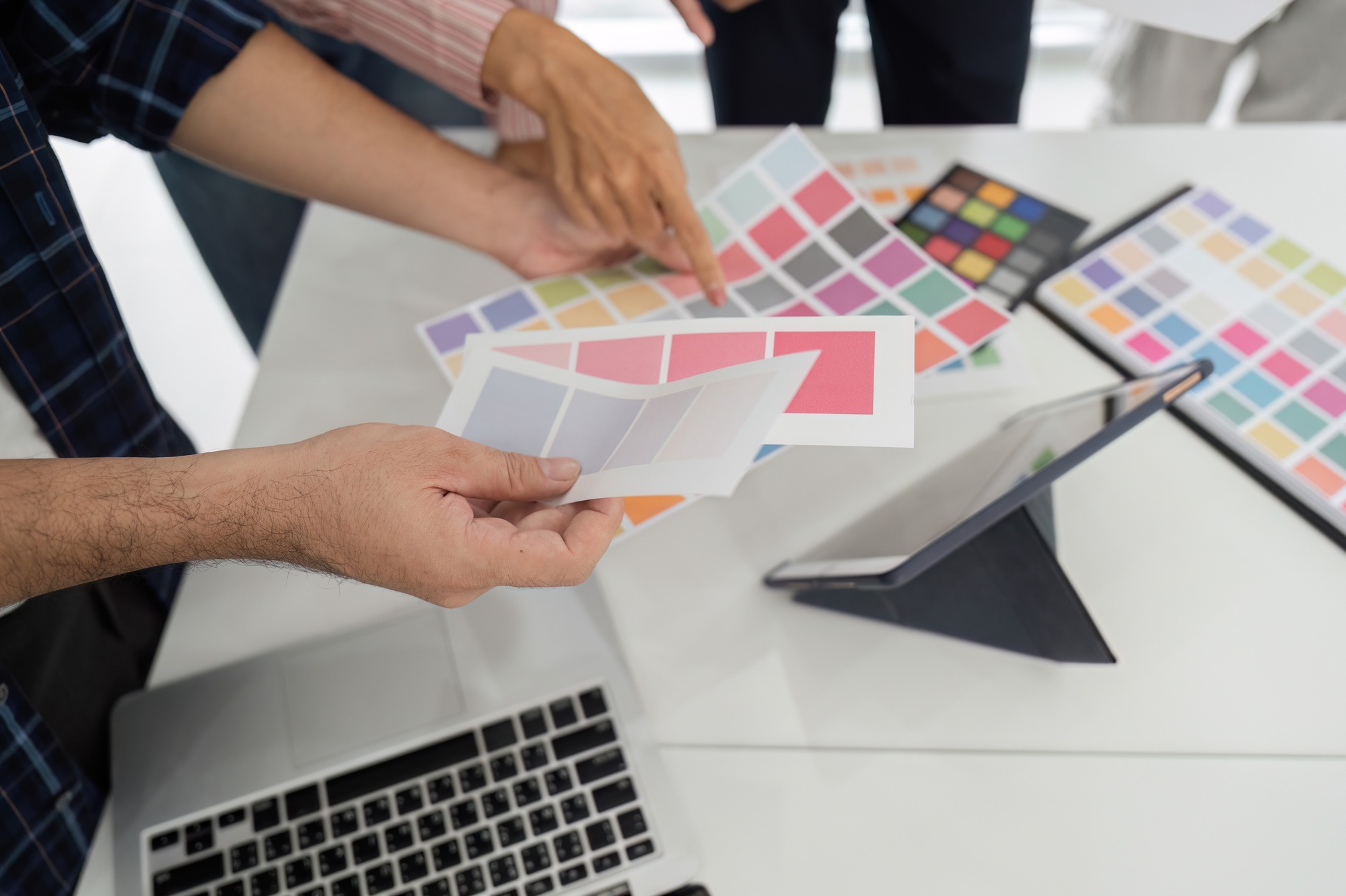 Diverse team discussing color palettes and design elements in a modern workspace.
