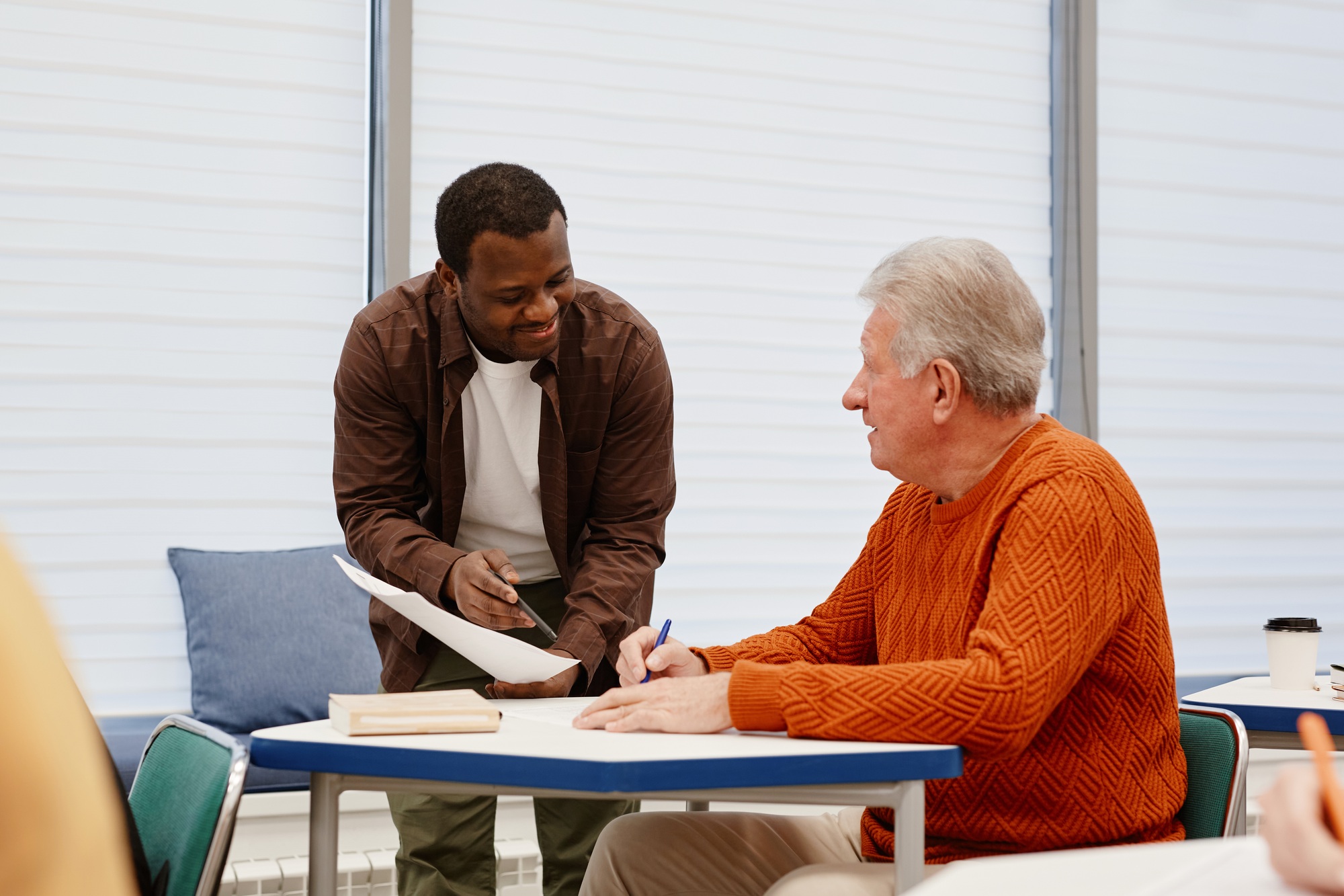 Teacher explaining material to senior man