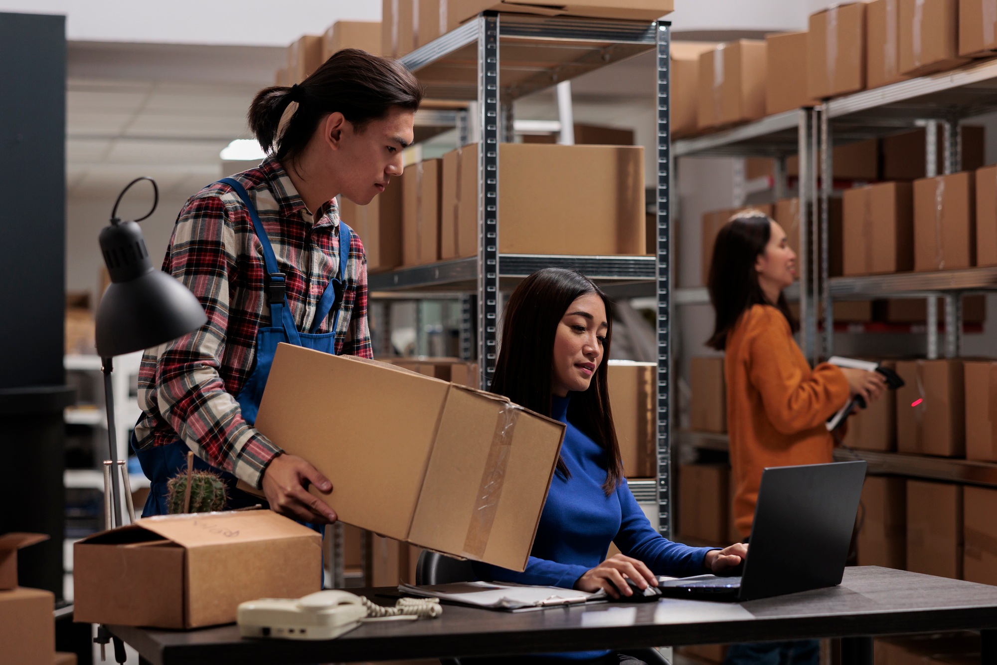 Warehouse asian employees managing ecommerce order fulfillment in storage
