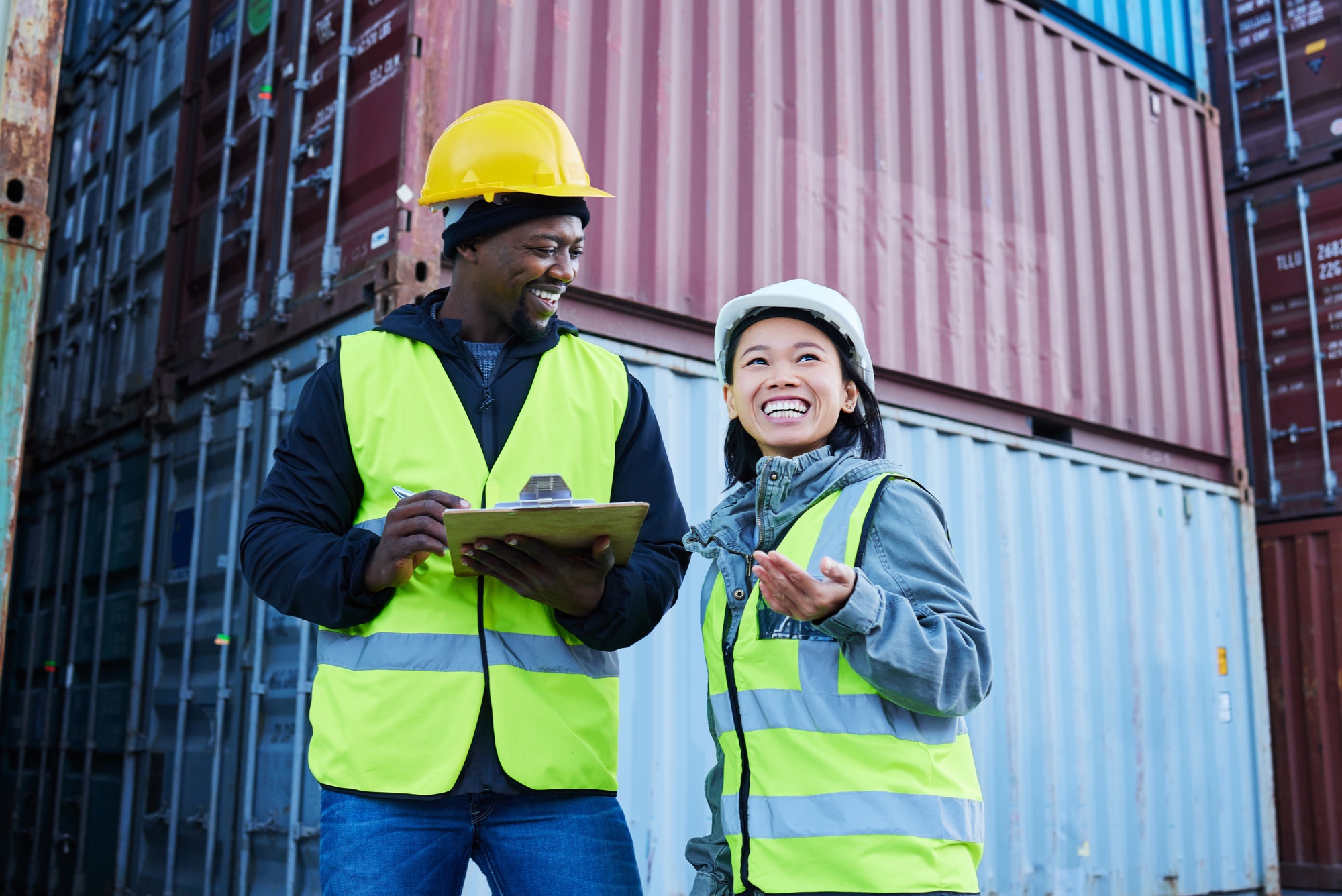 Warehouse, management and cargo stock with man and woman discuss checklist and laughing at factory