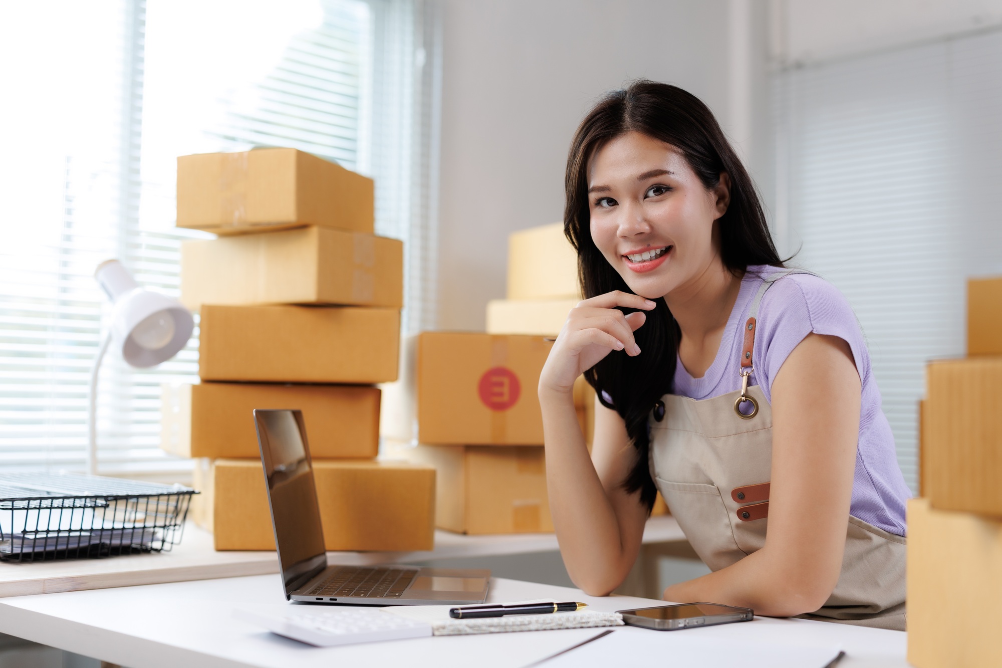 Young asian woman managing ecommerce business from home office